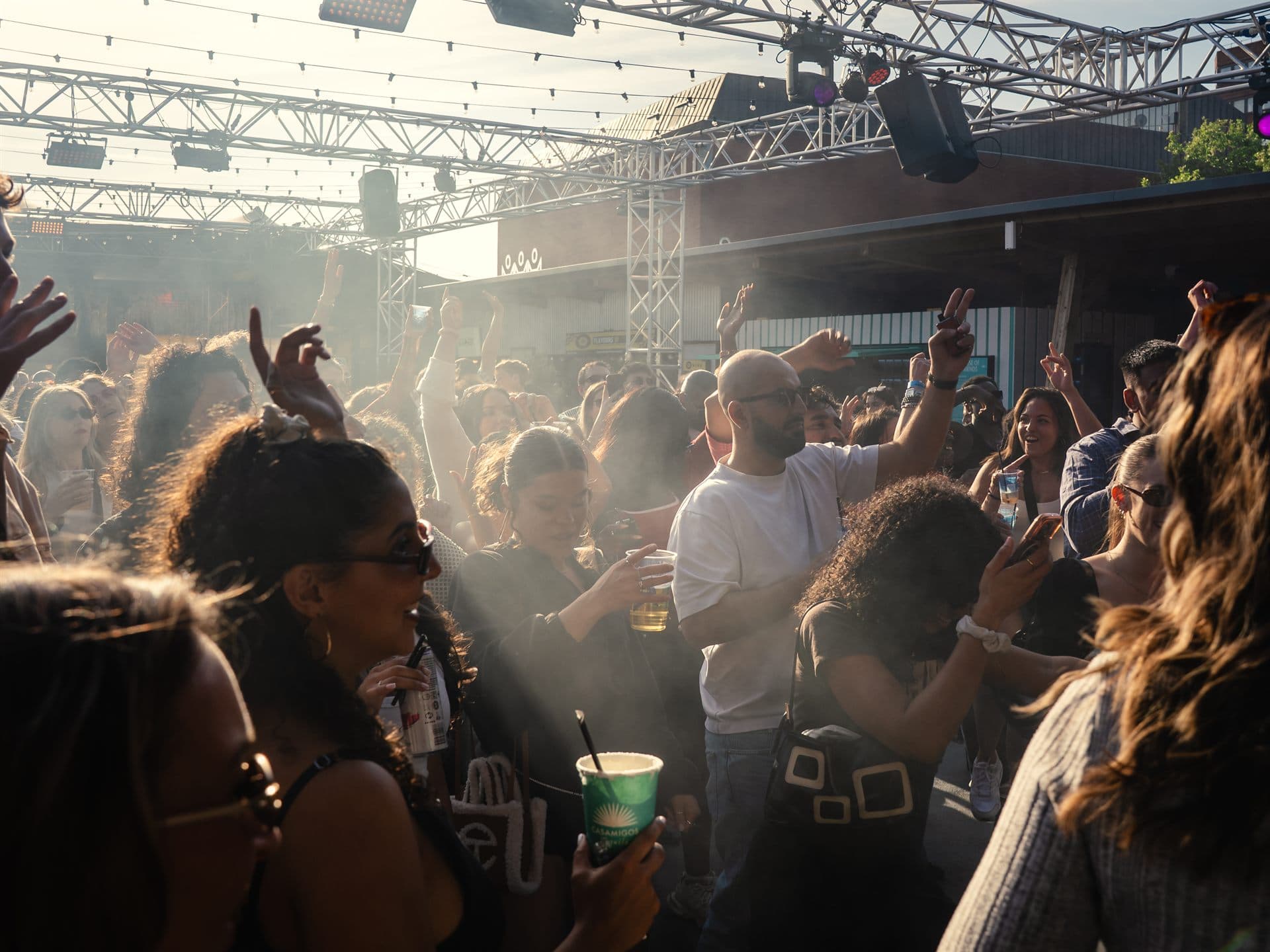 A packed daytime crowd dancing in the sunshine at Freight Brixton