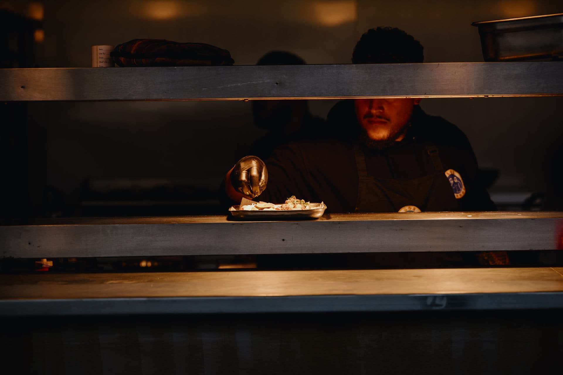 A chef plating a dish at a Freight Brixton food counter